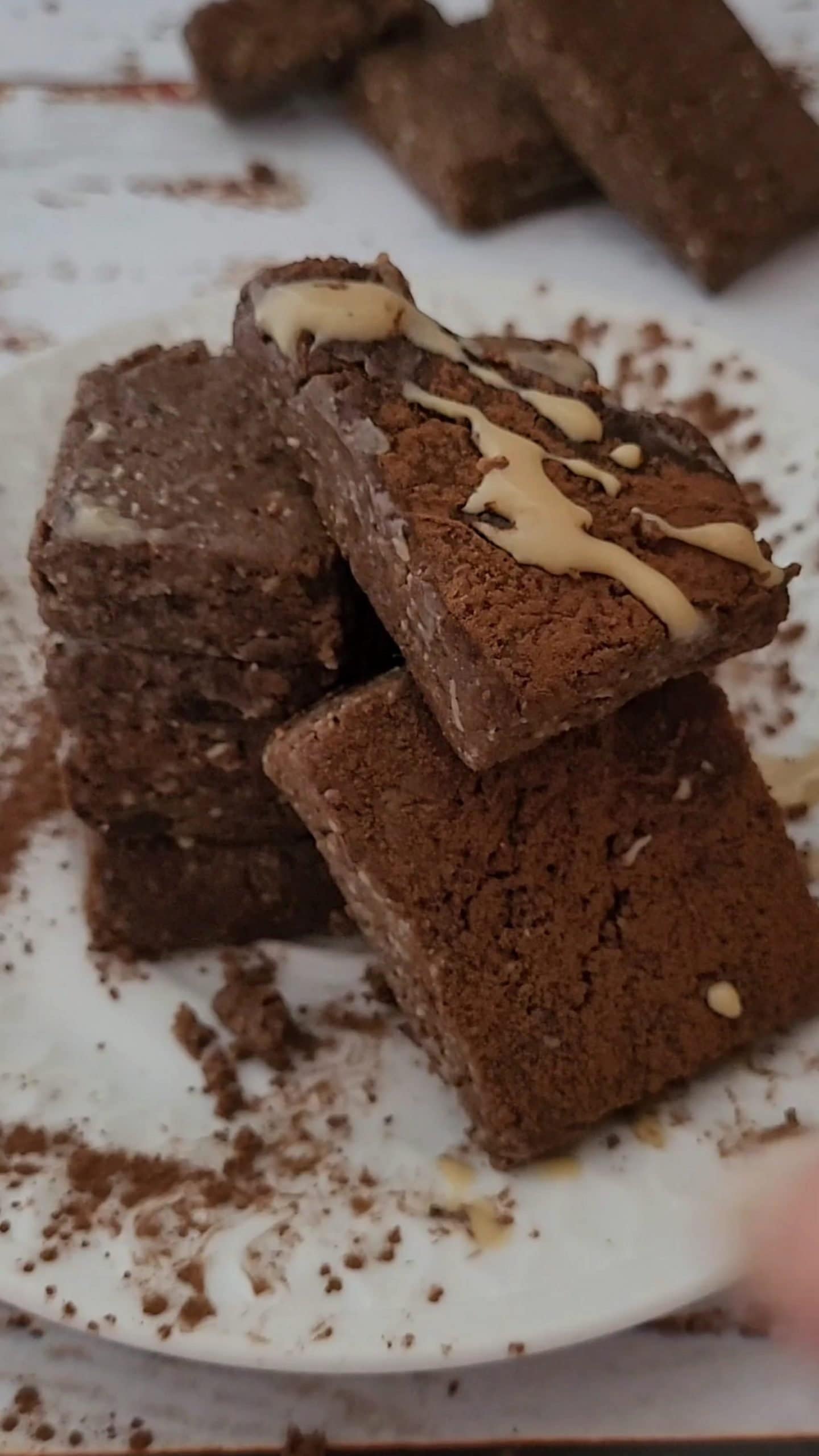 Raw chocolate protein bars stacked on a plate