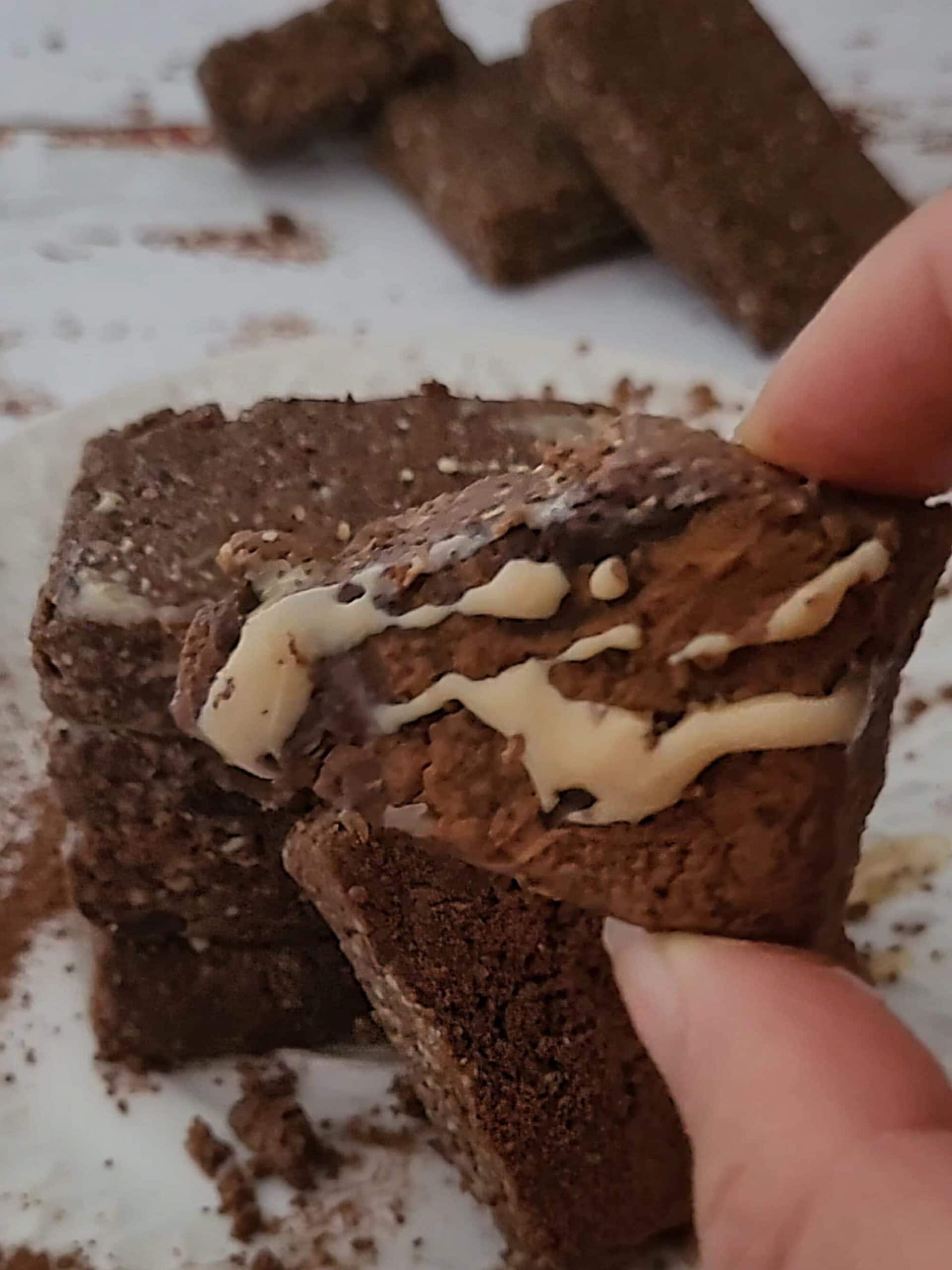 Raw chocolate protein bar broken in half showing texture