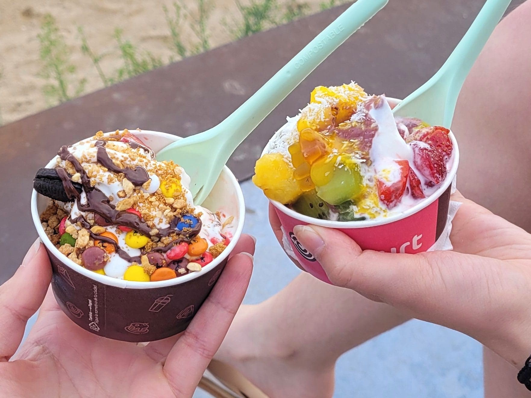 two frozen yogurt cups with toppings enjoyed on vacation