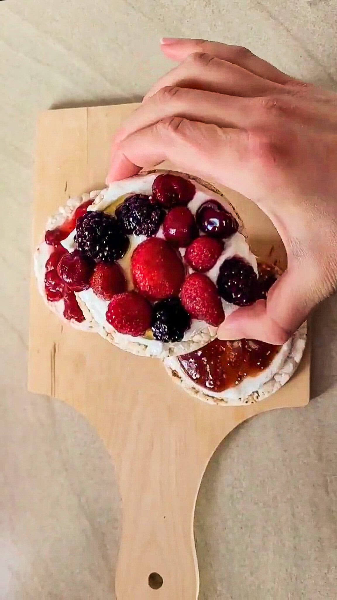 Assorted fresh berries on rice cakes for a healthy snack.