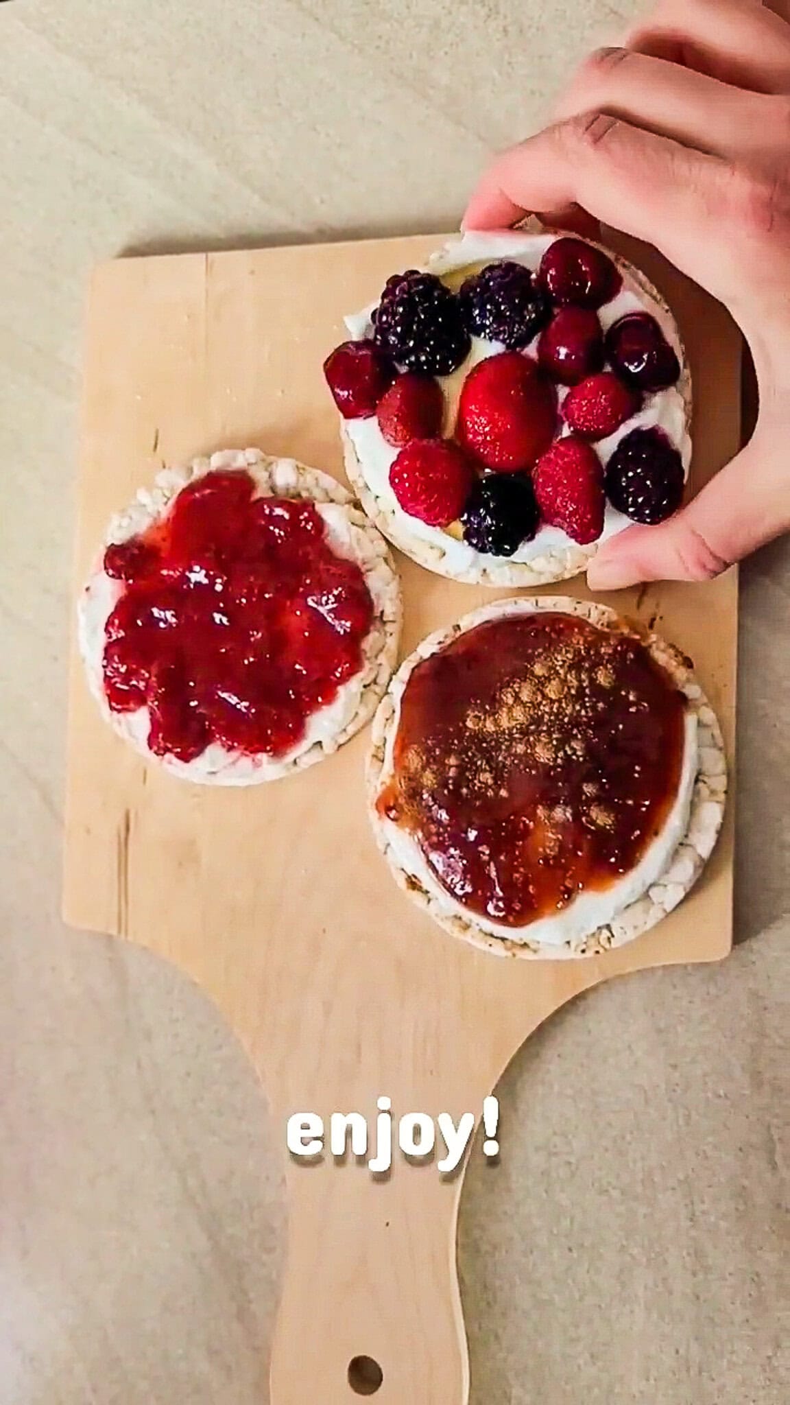 Assorted fresh berries with Greek yoghurt on rice cakes for a healthy snack.