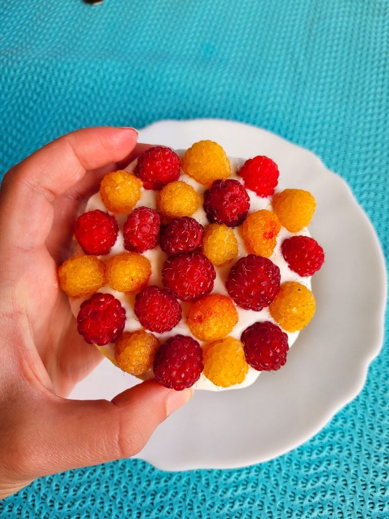 Rice cakes topped with fresh raspberries and Greek yoghurt  for a healthy snack.