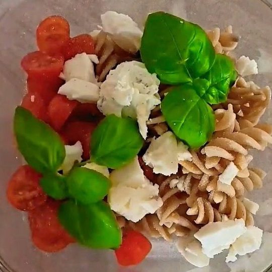 whole wheat pasta with cherry tomatoes, fresh basil and cheese in a glass container, simple healthy meal, vegetarian lunch idea