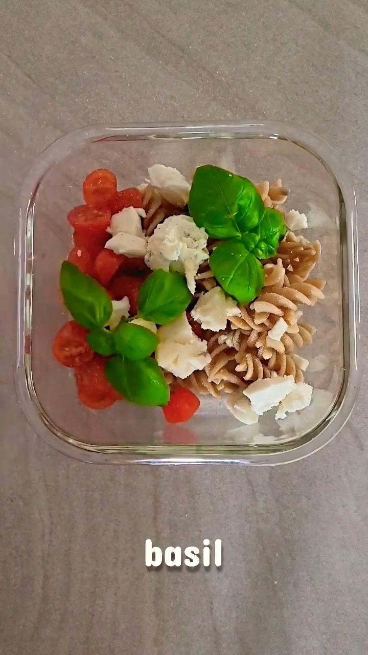 whole wheat pasta with cherry tomatoes, fresh basil and cheese in a glass container, simple healthy meal, vegetarian lunch idea