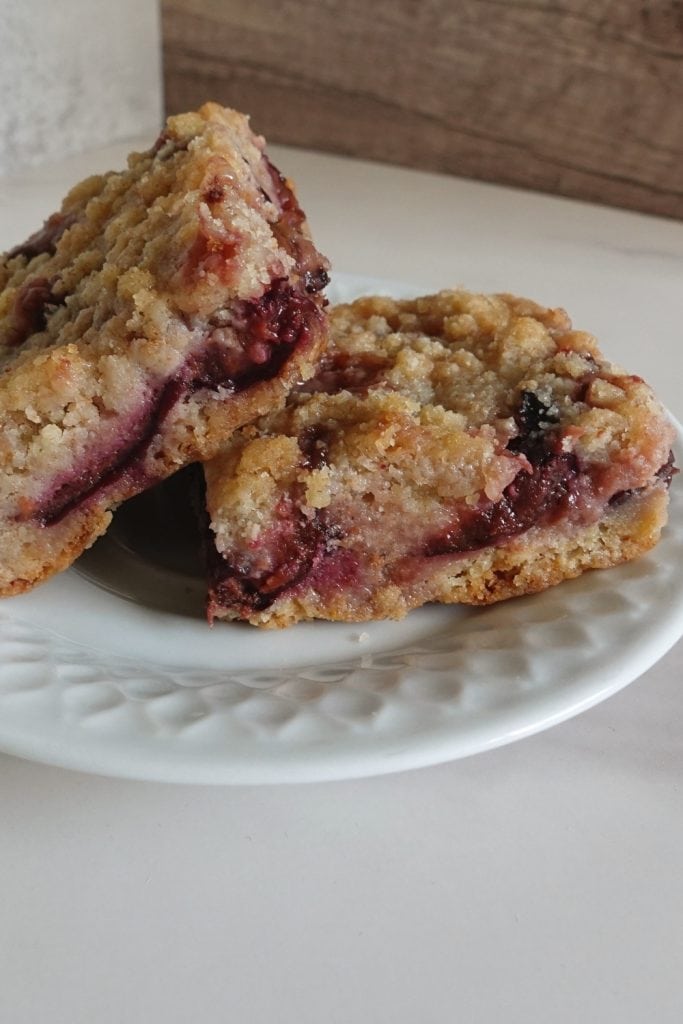 German plum cake recipe with buttery streusel topping and juicy baked plums on a white plate