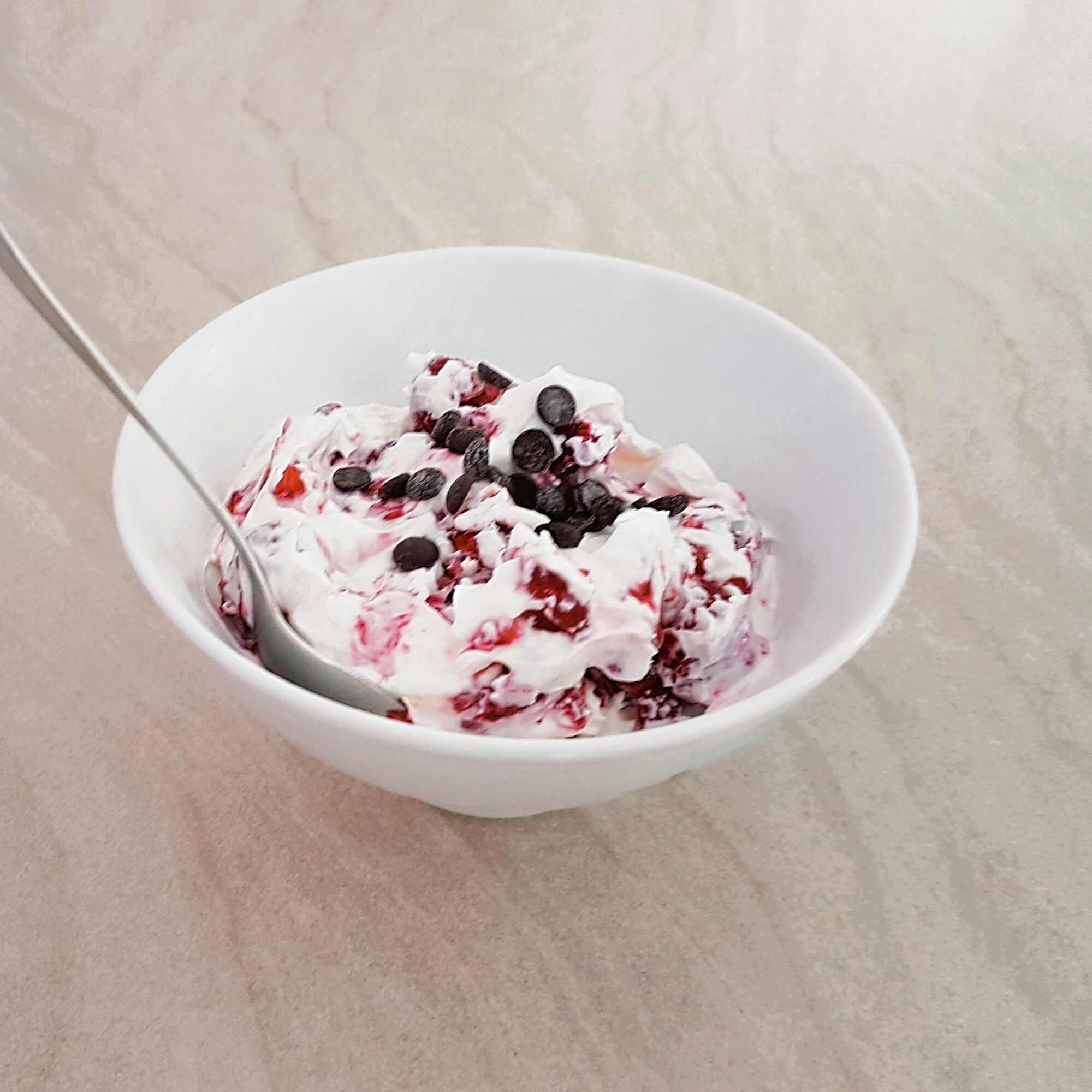 Creamy strawberry Greek yogurt bowl with blueberries in a white bowl.