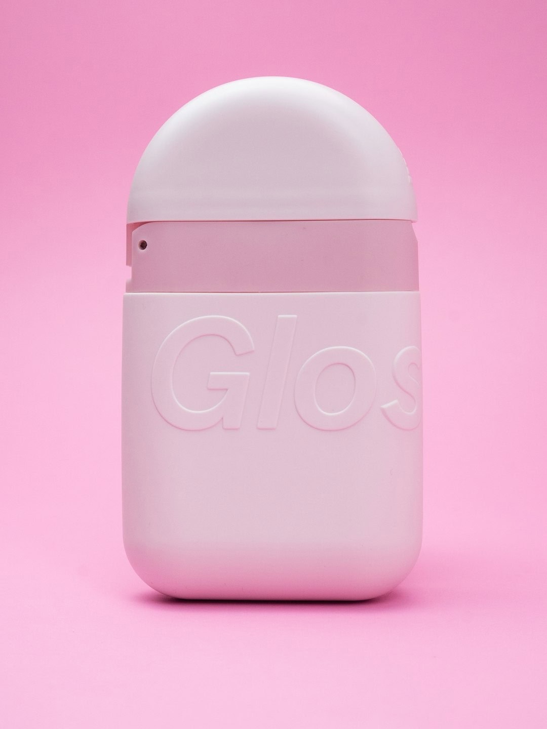 AirPods case in pastel pink with embossed "Glo" logo on a matching pink background.