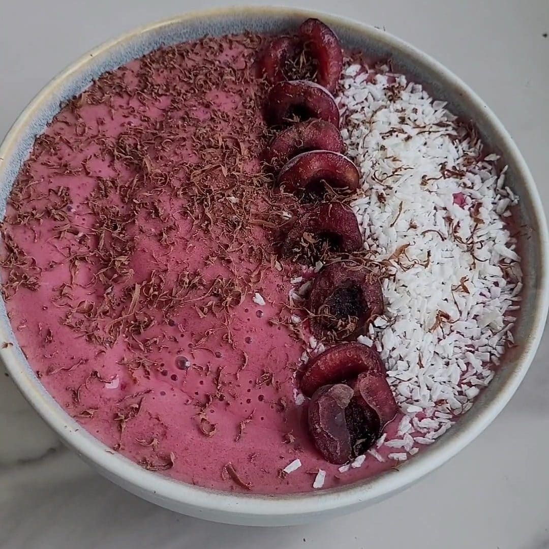 Delicious cherry frozen yogurt topped with cherries, coconut, and chocolate shavings.