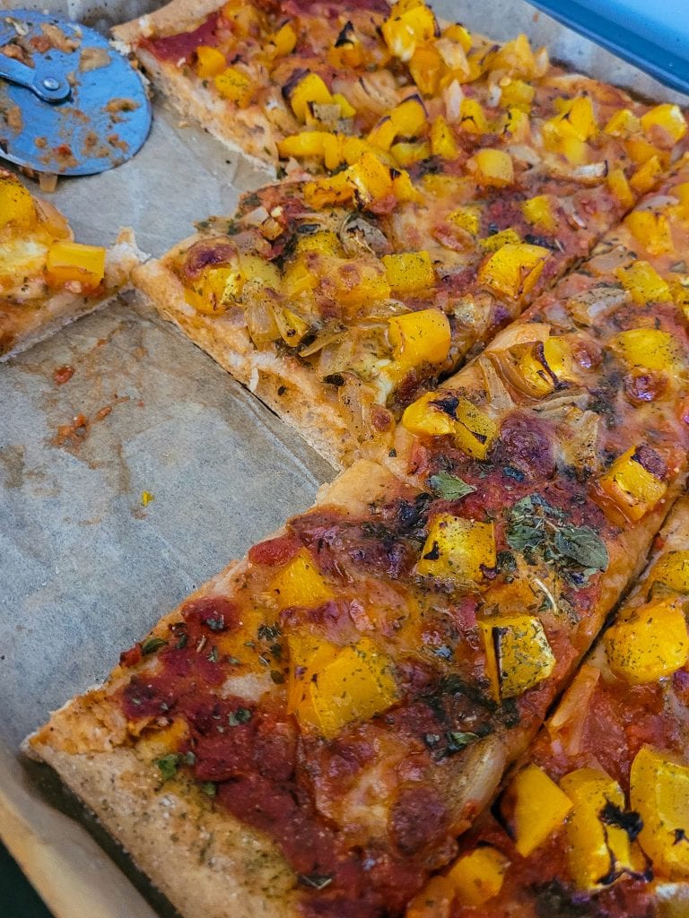 Delicious homemade pizza topped with yellow squash and herbs.