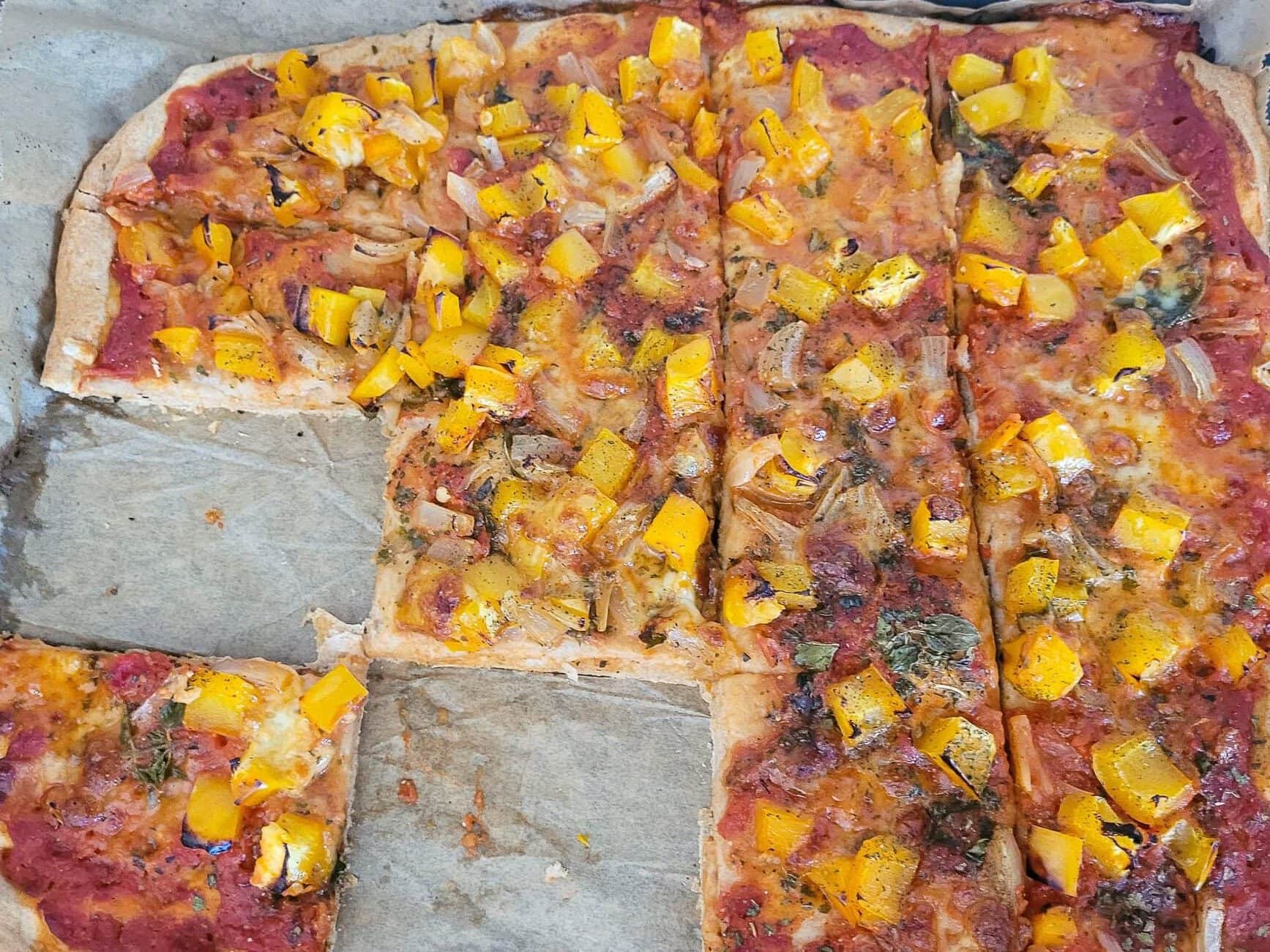 Vegetarian pizza topped with yellow bell peppers and vegetables for a healthy diet.