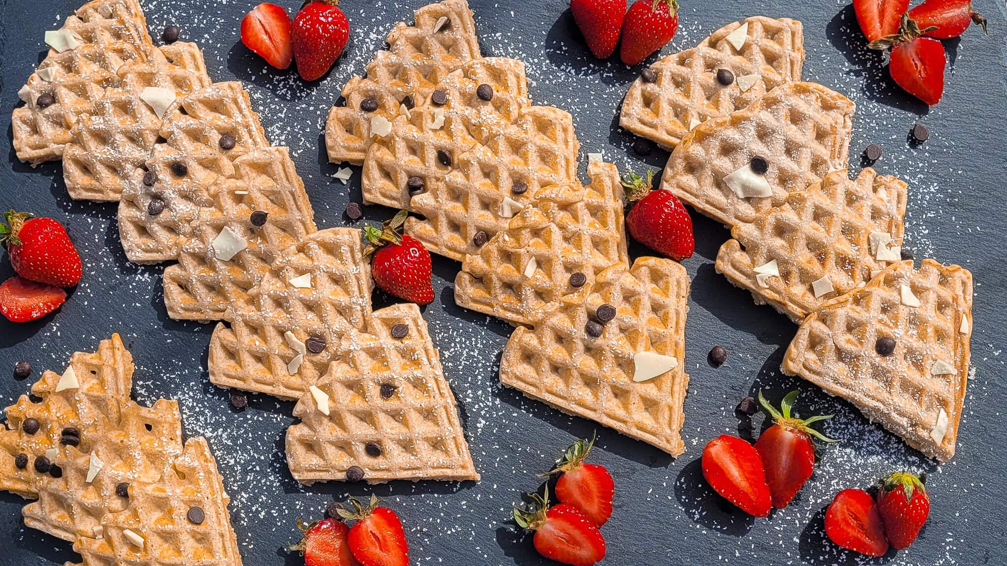 Healthy whole grain waffles topped with strawberries and chocolate chips.