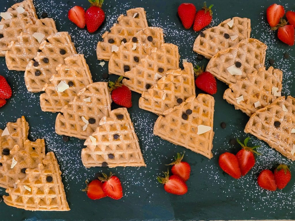 Delicious whole grain waffles topped with fresh strawberries and chocolate chips.