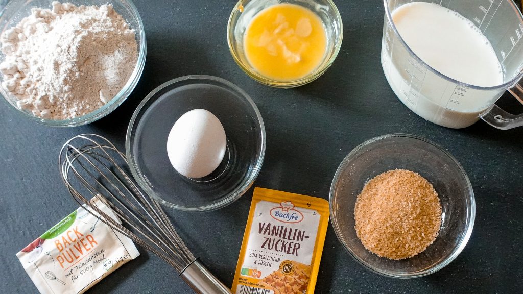 Ingredients for healthy whole grain waffles including flour, egg, milk, sugar, and vanilla extract.