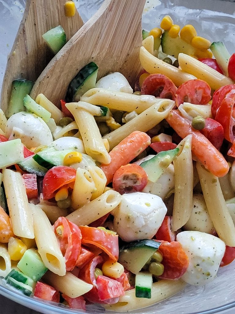 Colorful pasta salad with vegetables and mozzarella cheese for a healthy meal.