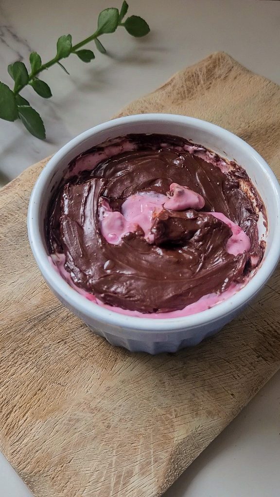 Creamy Greek yogurt dessert with a crunchy chocolate shell in a white bowl.