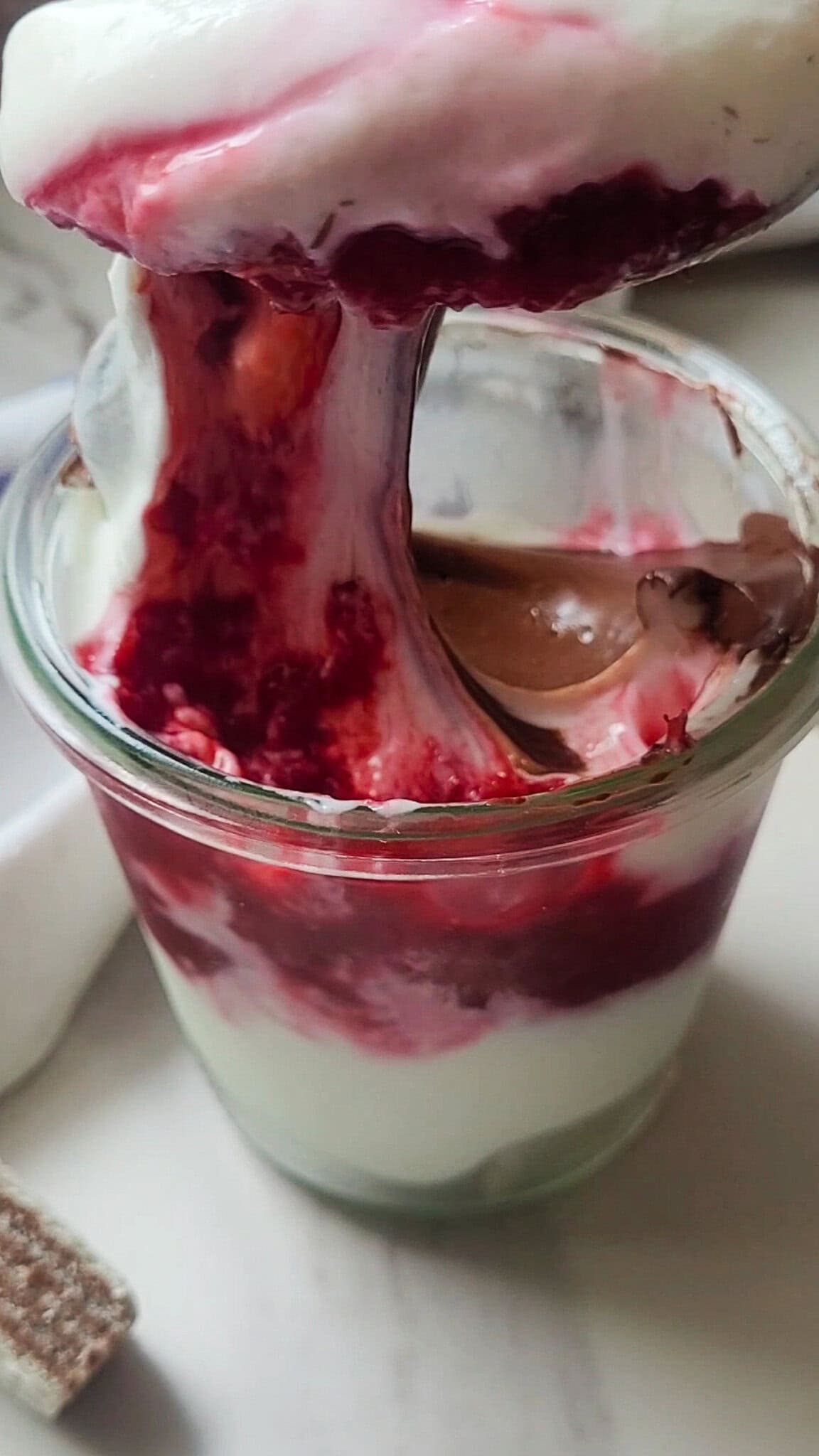 Delicious layered raspberry and Greek yogurt dessert in a glass.