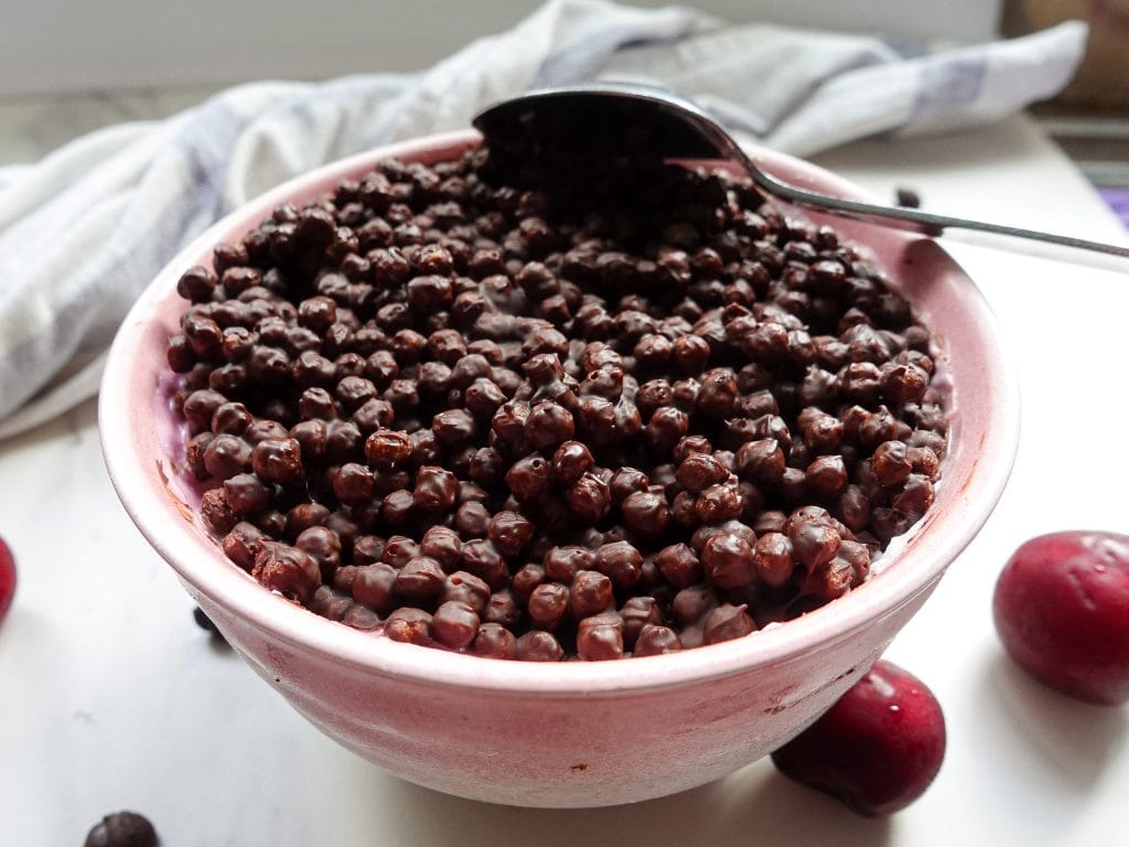 High protein chocolate dessert with magic shell in pink bowl.