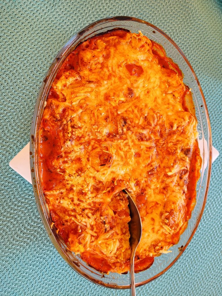 Baked tortellini with cheese and tomato sauce in a glass dish.