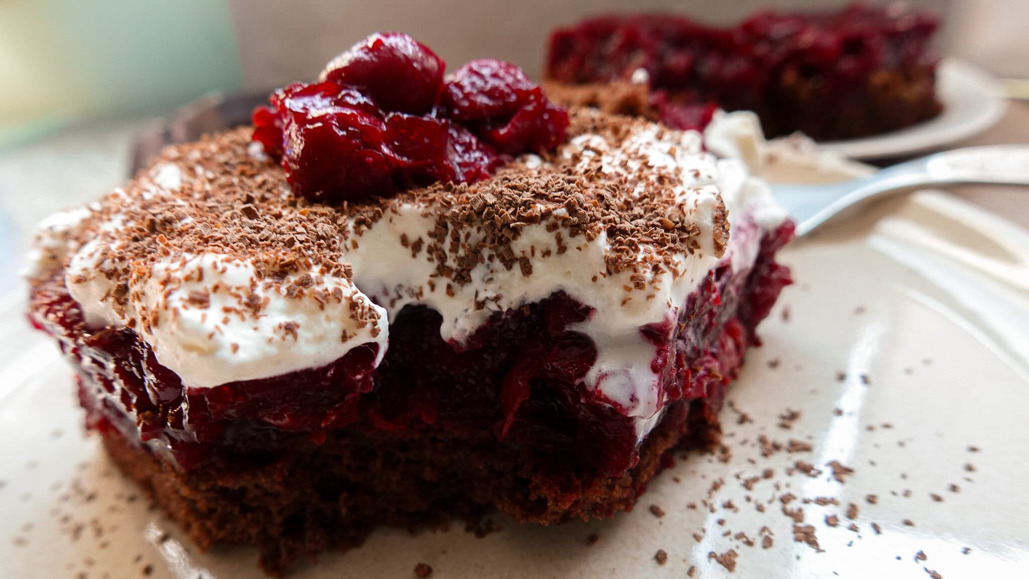 Schwarzwälderkirsch cake on a plate topped with cherries