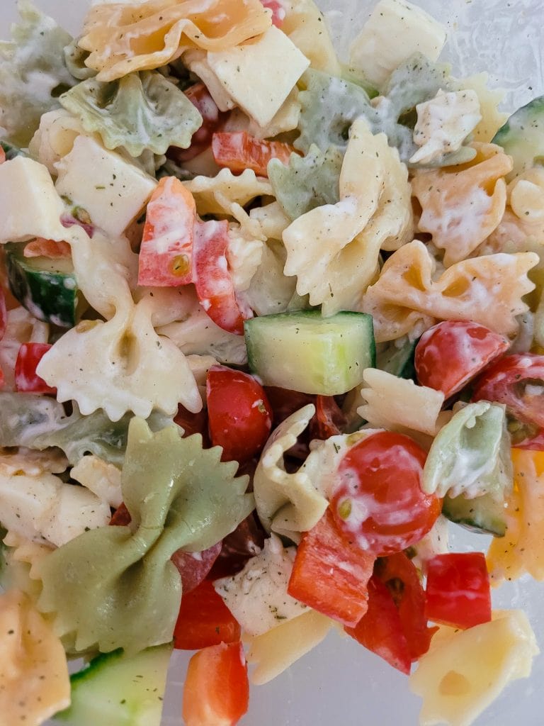 Colorful healthy pasta salad with vegetables and cheese.