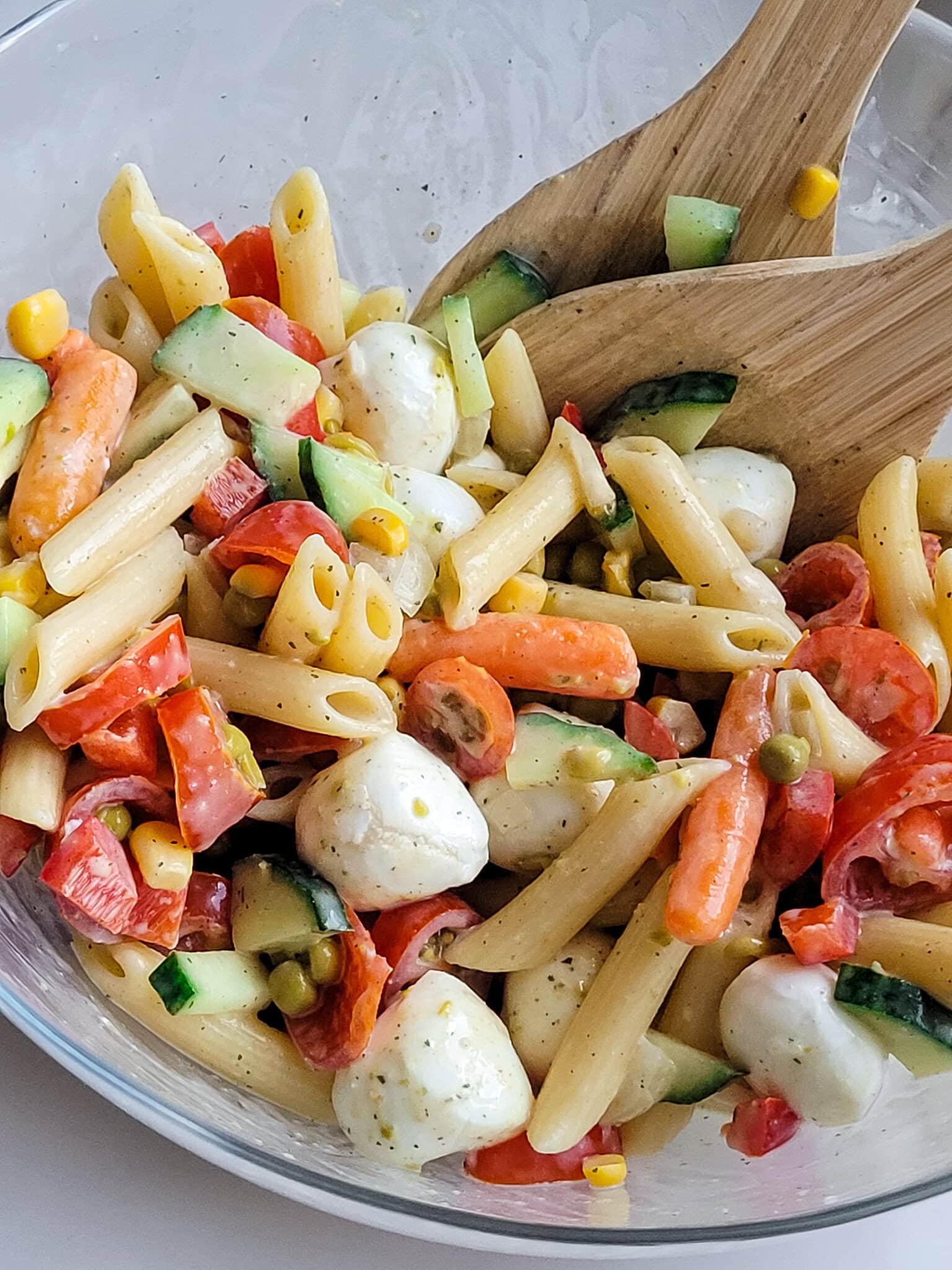 Colorful pasta salad with vegetables and mozzarella cheese.