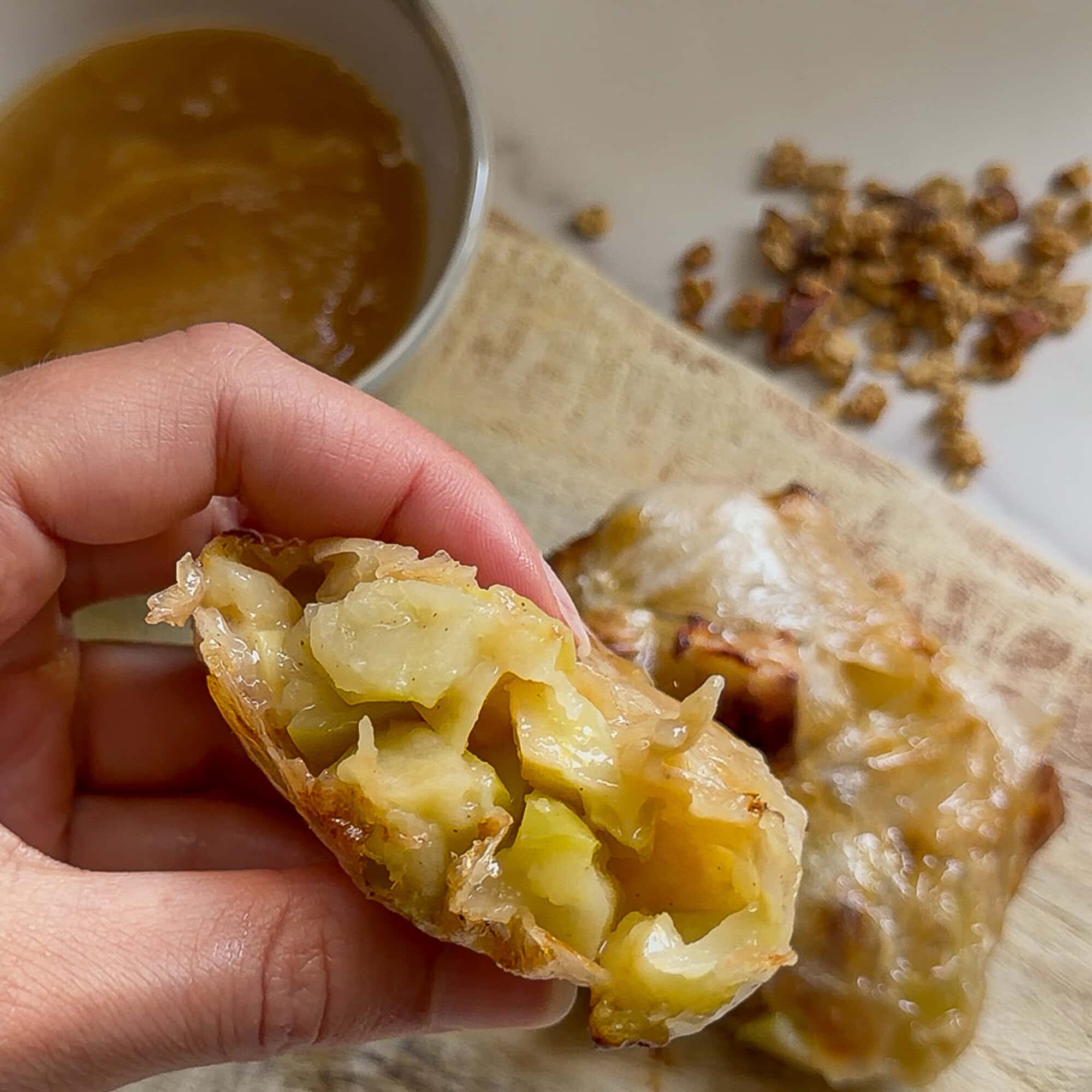 Close-up of baked apple pocket with caramelized filling and flaky crust.