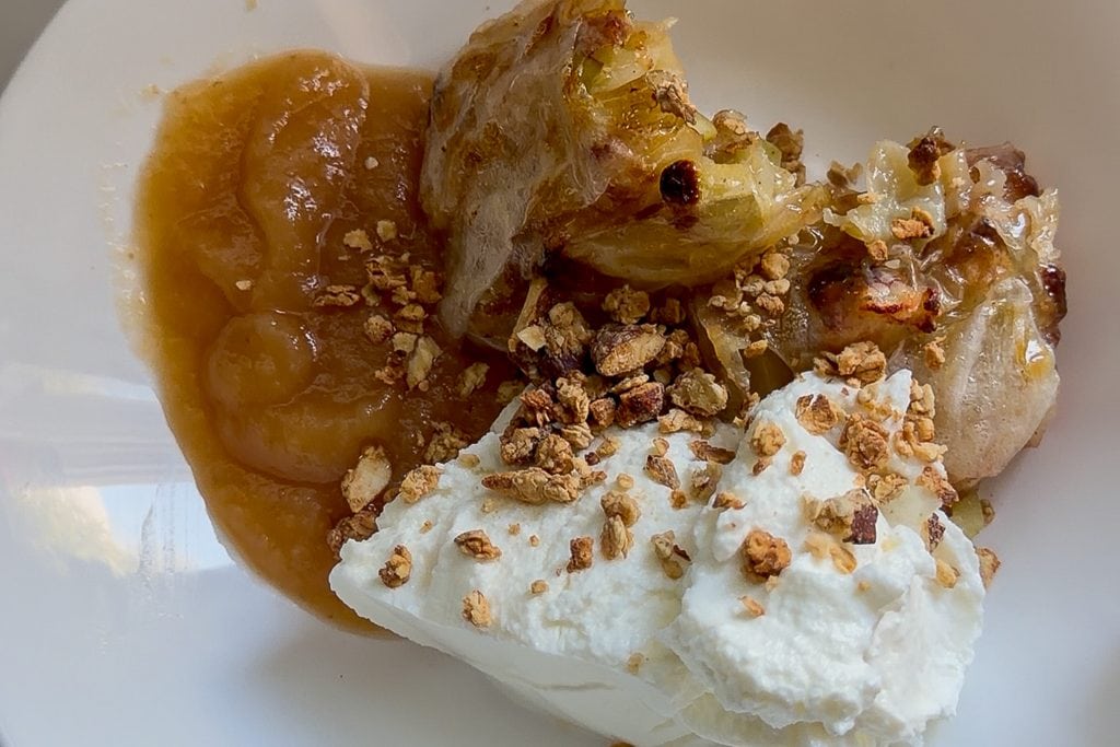 Baked apple dessert with caramel sauce and whipped cream.