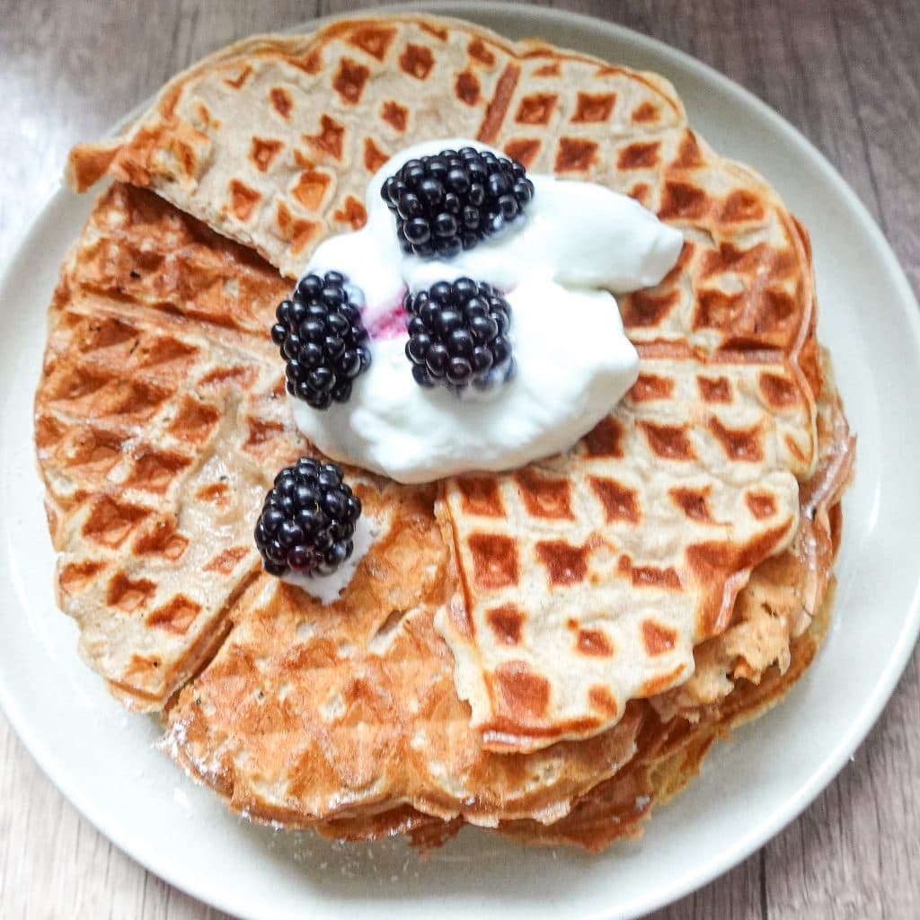 Fluffy waffle topped with blackberries and yogurt for a nutritious breakfast.