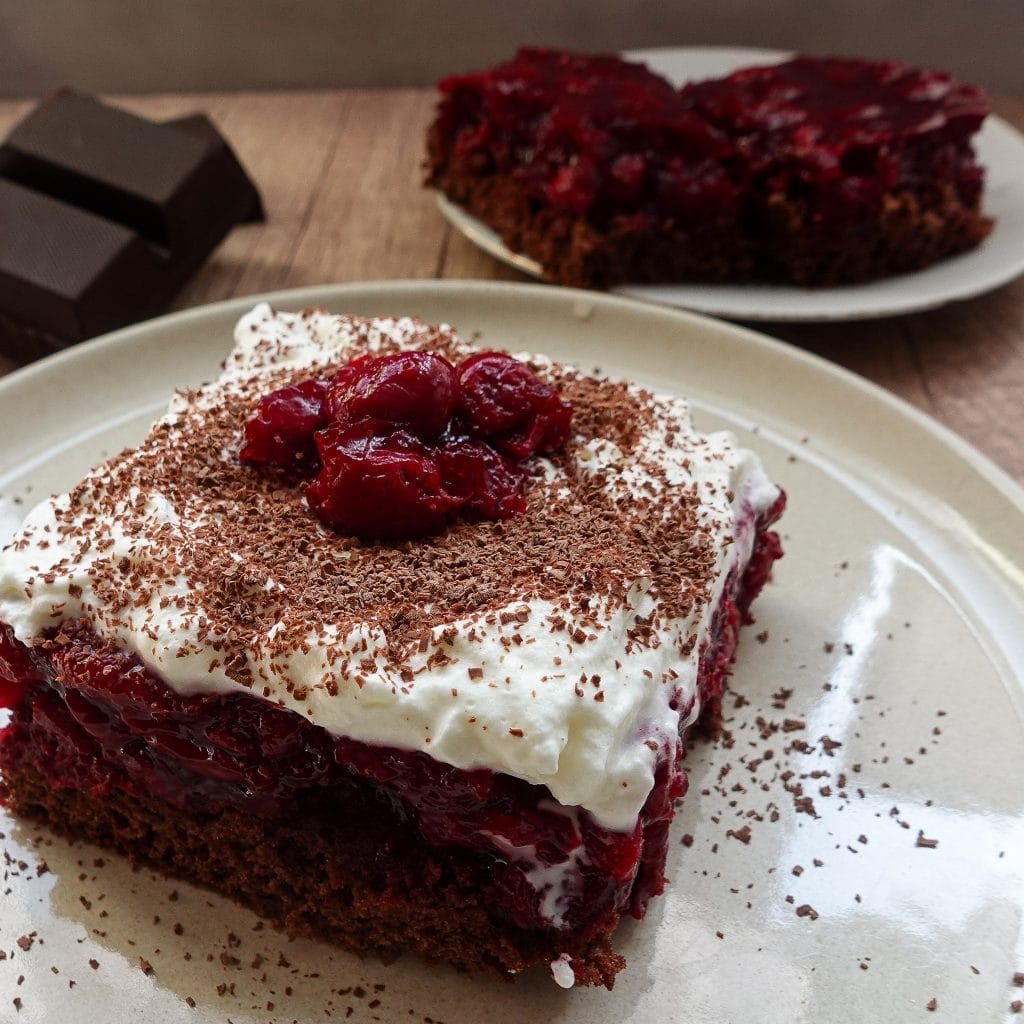 Delicious Black Forest cake slice with cherries and whipped cream.