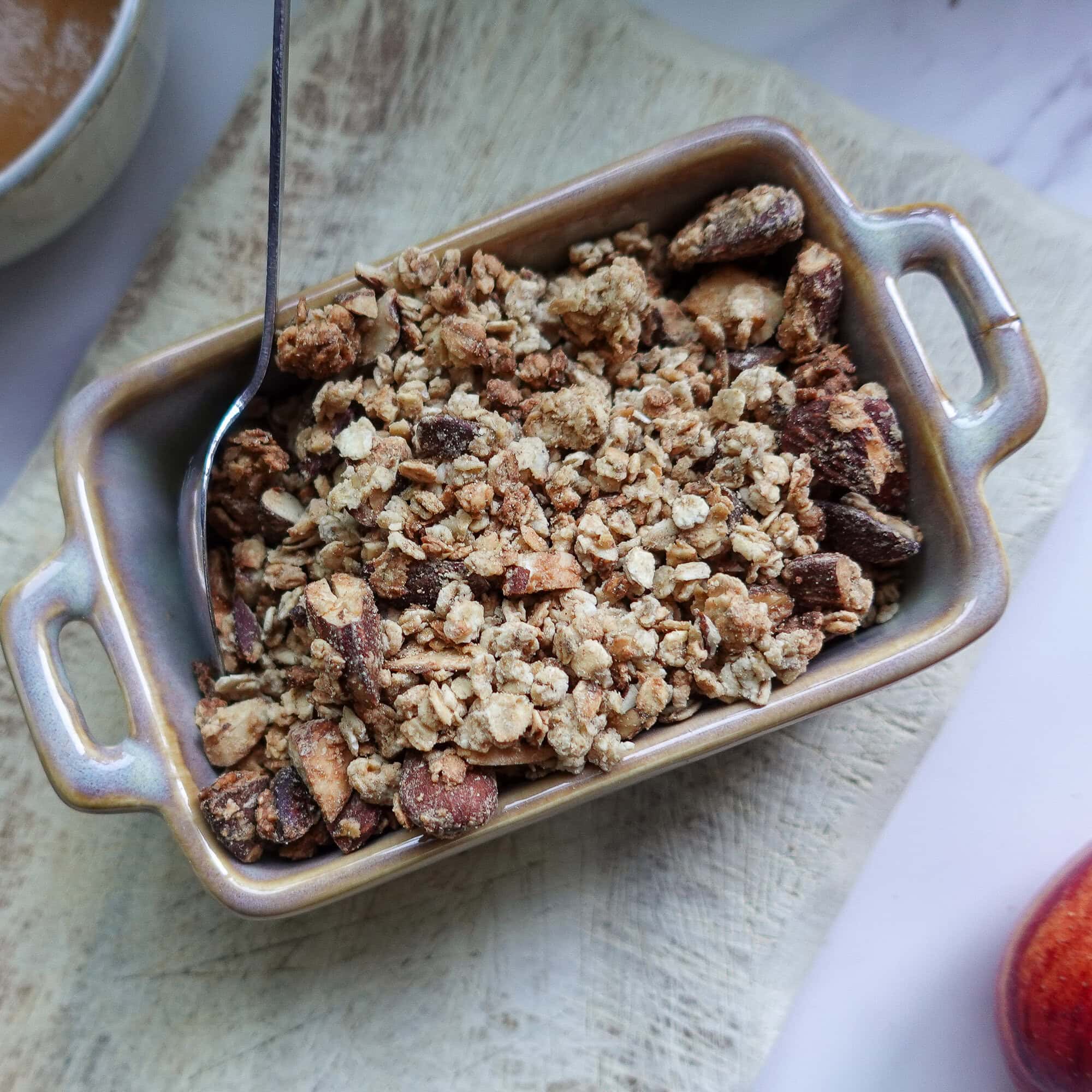 Crunchy homemade granola with oats and nuts in a baking dish.