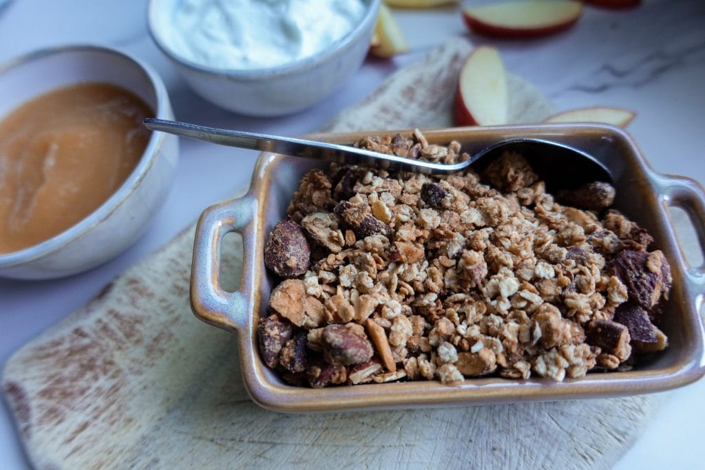 Crunchy homemade granola with oats and nuts in a baking dish.