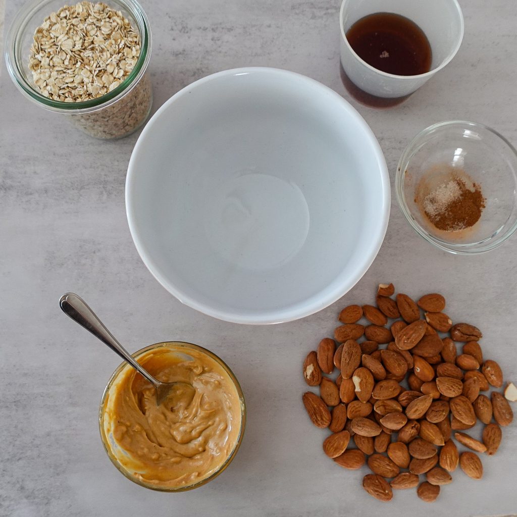 Ingredients for air fryer granola including almonds, honey, oats, and spices.