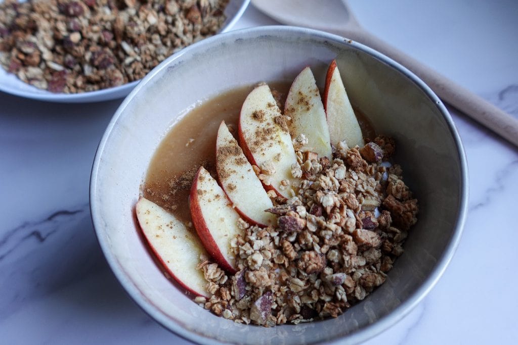 Apple yogurt bowl with granola and sliced apples for a nutritious breakfast.