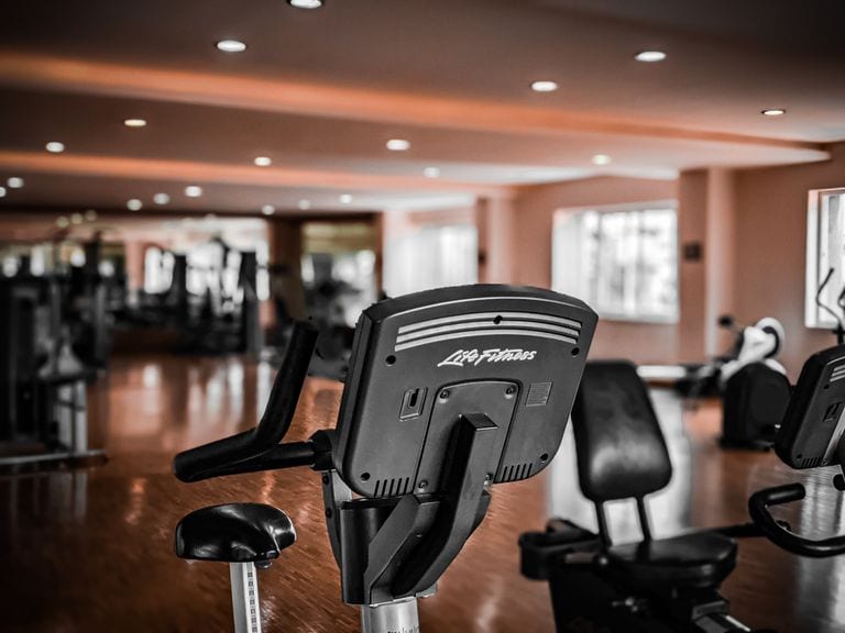 Indoor gym with cardio machines and fitness equipment for workouts.