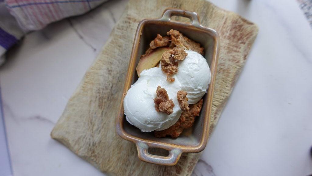 Small batch apple crumble with vanilla ice cream and crumble topping.