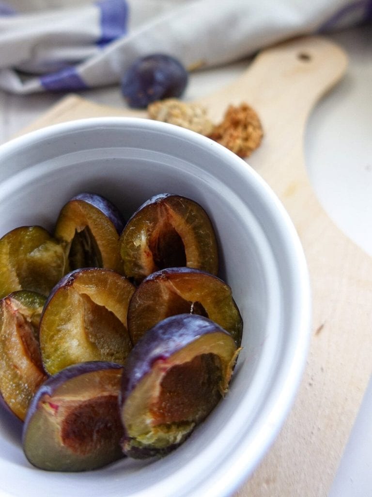 Close-up of sliced fresh plums in a white bowl for dessert.