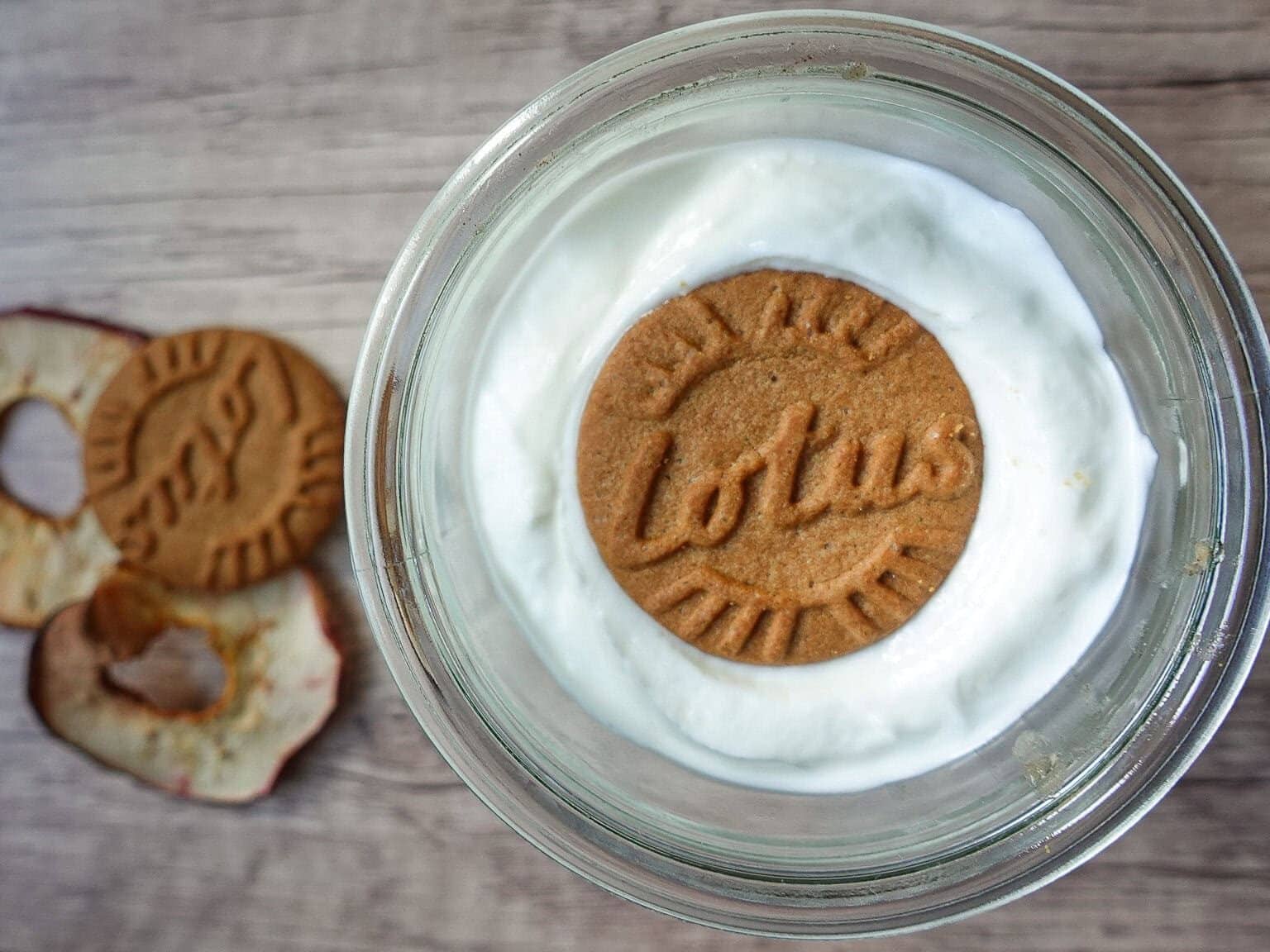 Yogurt dessert topped with Lotus Biscoff cookie and cookies on side.