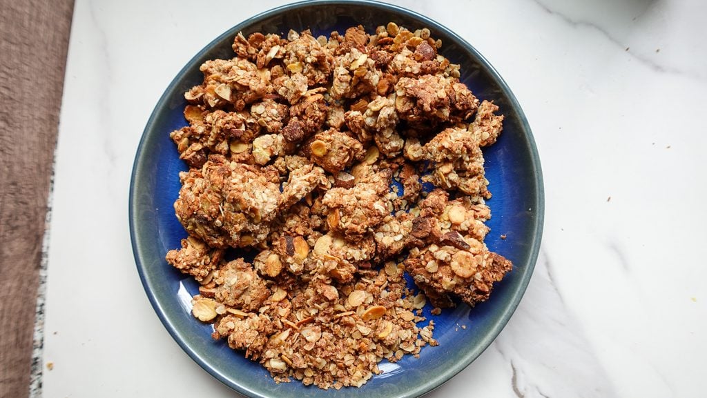 Crunchy homemade granola clusters on a blue plate, perfect for healthy breakfast or snack.