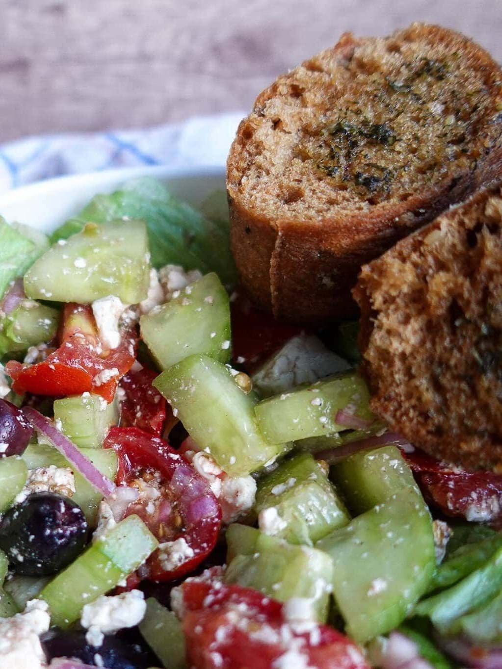 Fresh Greek salad with feta, mozzarella, and vegetables on a plate.